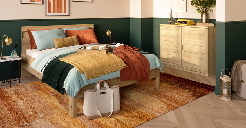 Bett und Kommode aus Holz im hellen Schlafzimmer