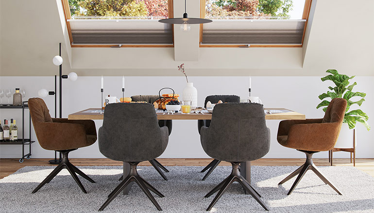 Schlicht eingerichtetes Esszimmer mit Massivholz Tisch und gepolsterten Stühlen in Grau und Cognac