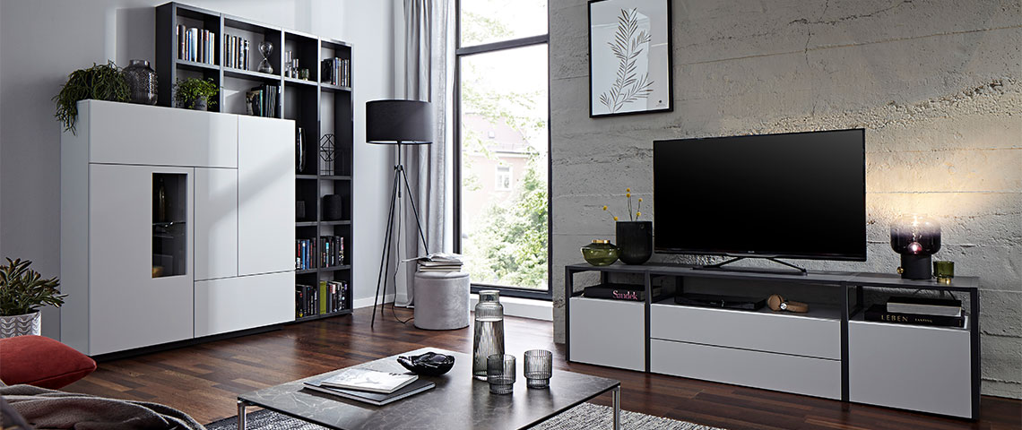 Wohnwand mit weißem Highboard und aufgesetztem Regal wie einem passenden TV-Lowboard
