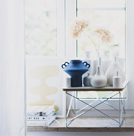 Helles Fenster und Fensterbank, die mit Vasen und Coffee Table Books dekoriert ist