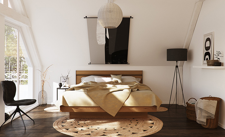 Aufgeräumtes Schlafzimmer mit Massivholzbett und einem schwarzen Stuhl